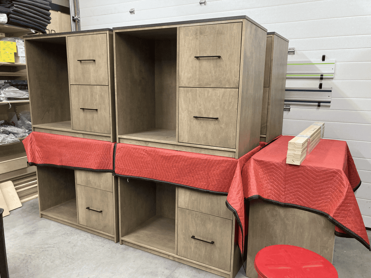 Custom wood cabinetry with drawers and shelving, displayed in a workshop setting, emphasizing craftsmanship and quality materials by Beaver Custom Builds.