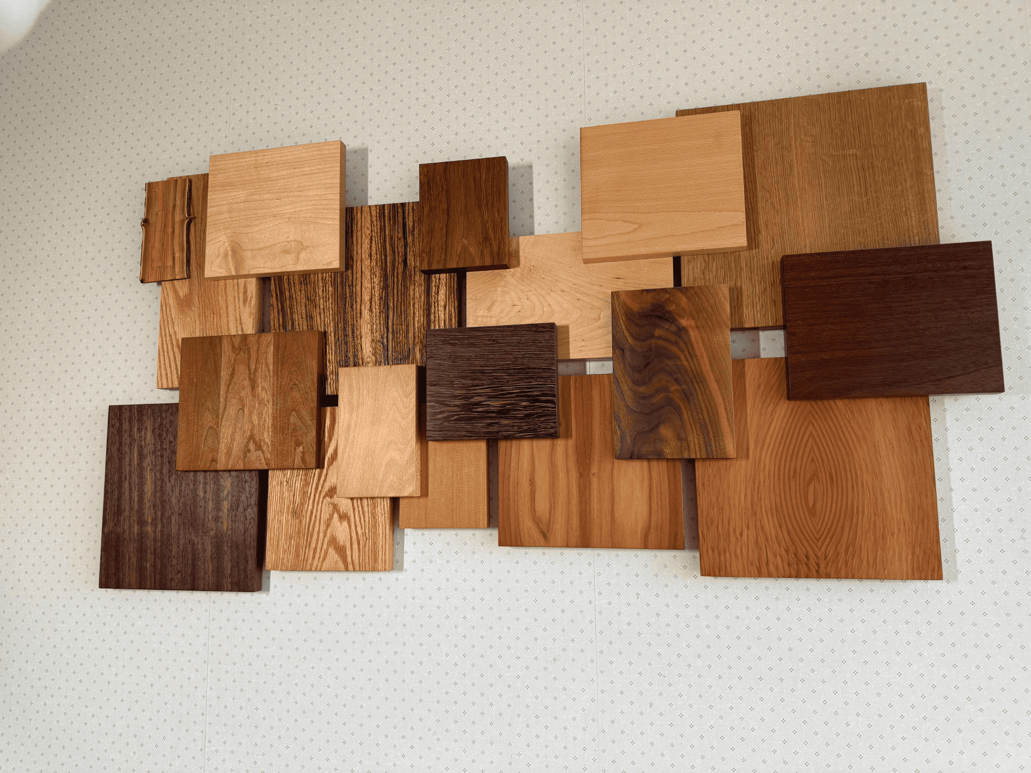 Wood panel art installation featuring various wood types and finishes, showcasing craftsmanship in custom woodworking by Beaver Custom Builds.