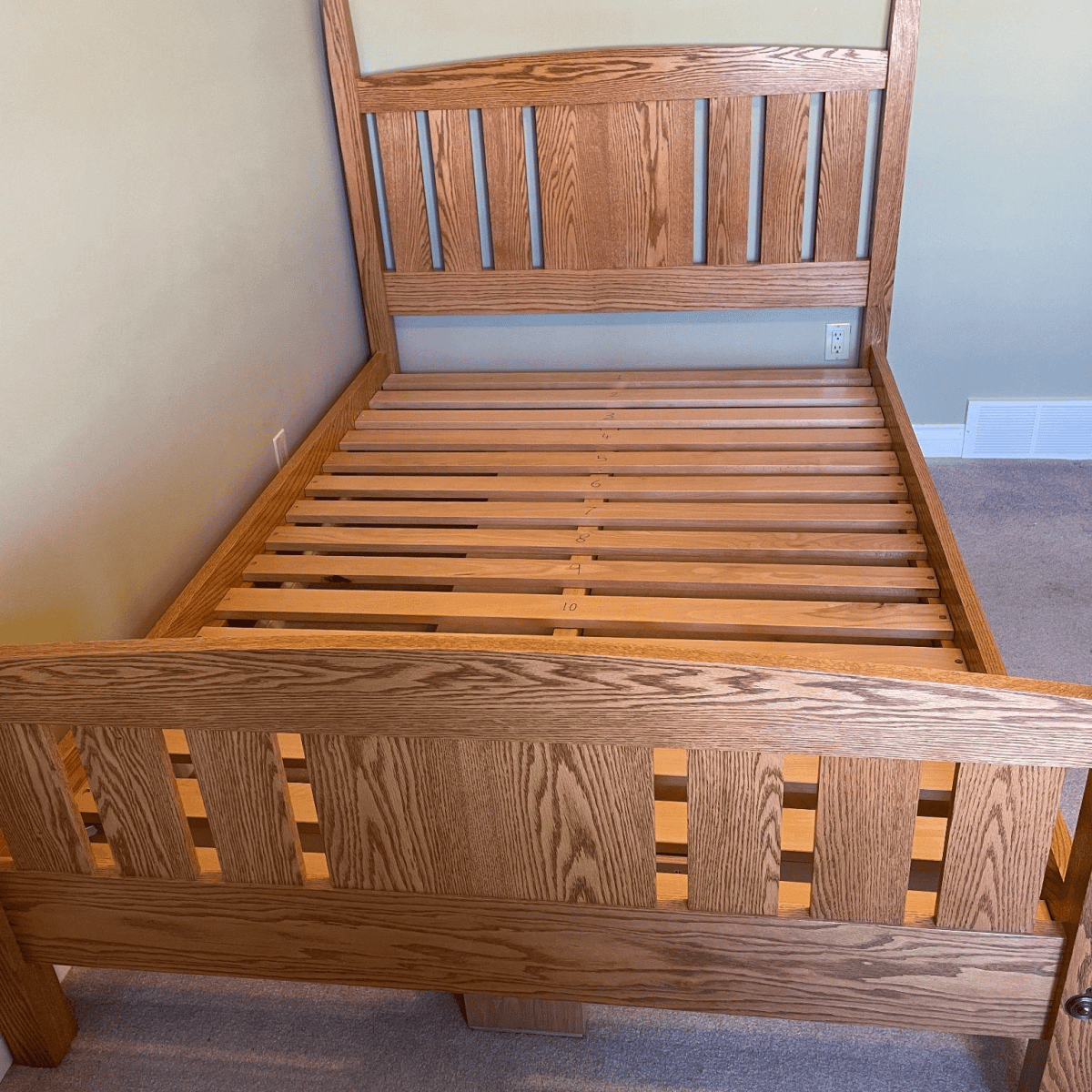 Custom wooden bed frame with slatted headboard and footboard, showcasing quality craftsmanship and design by Beaver Custom Builds.