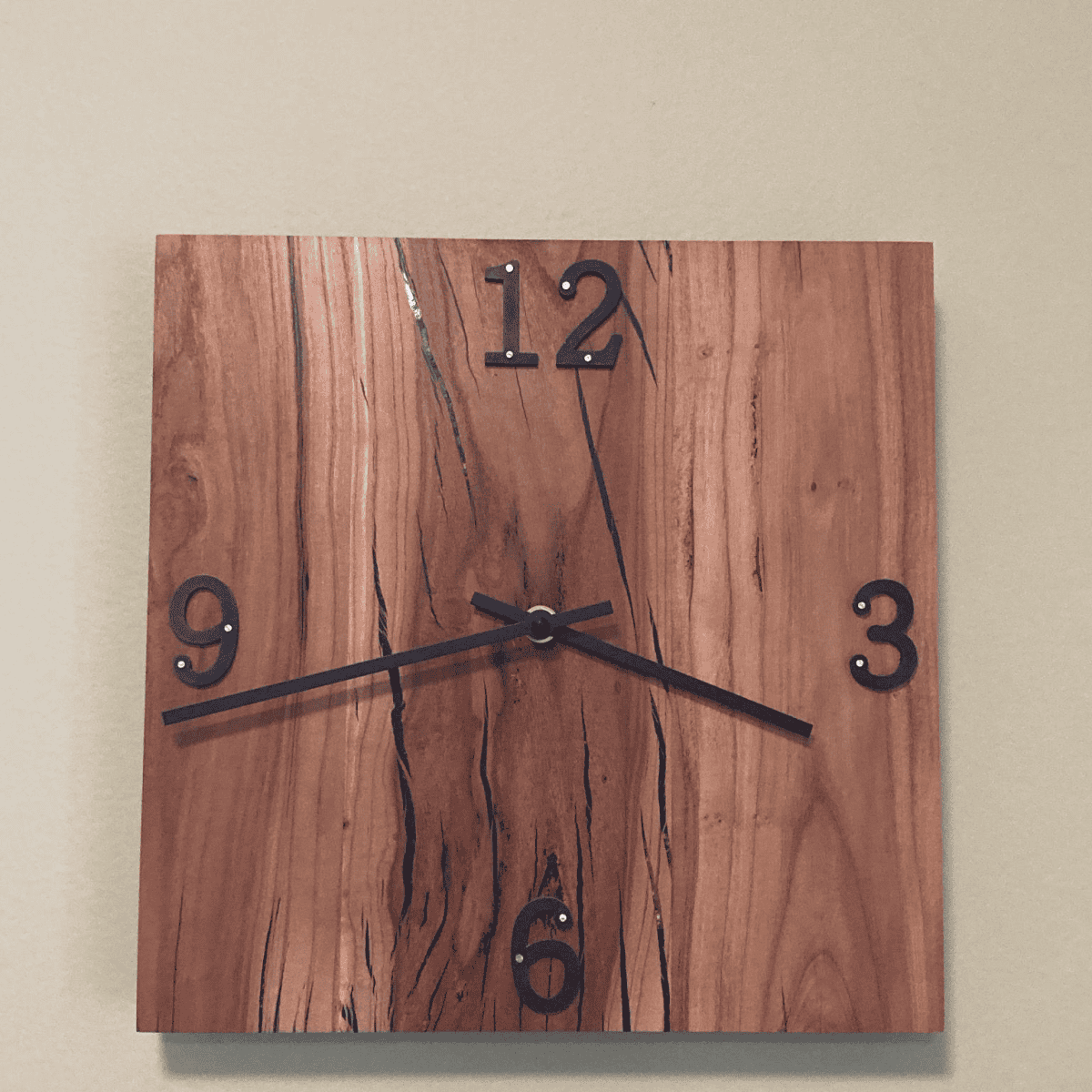 Wooden wall clock with natural grain finish, featuring black hour markers and hands, showcasing custom woodworking craftsmanship.
