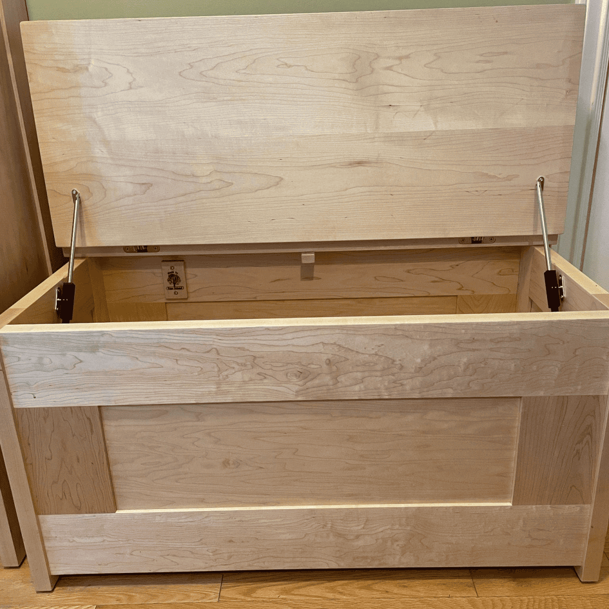 Custom wooden storage chest with an open lid, showcasing quality craftsmanship and natural wood grain.