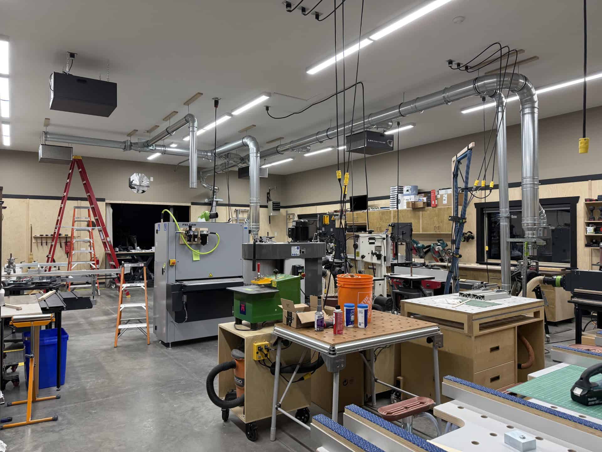 Workshop interior of Beaver Custom Builds featuring woodworking machinery, tools, and equipment, showcasing a well-organized space for custom furniture production.
